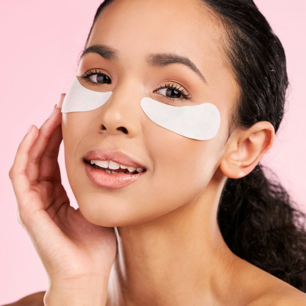 Eye patch, face mask and beauty of a woman with natural skin glow on a pink background. Dermatology