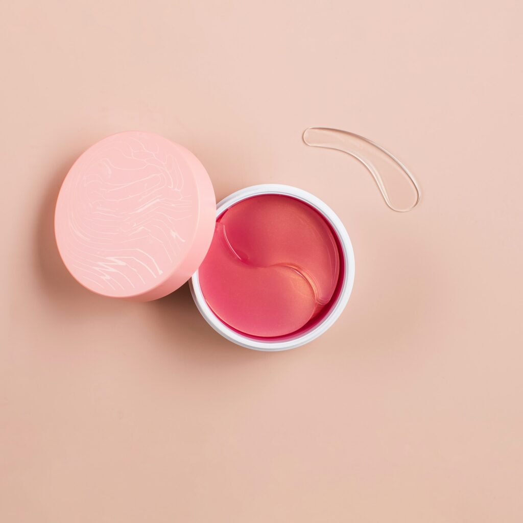 Pink hydrogel patches for youthful skin around the eyes in a plastic box