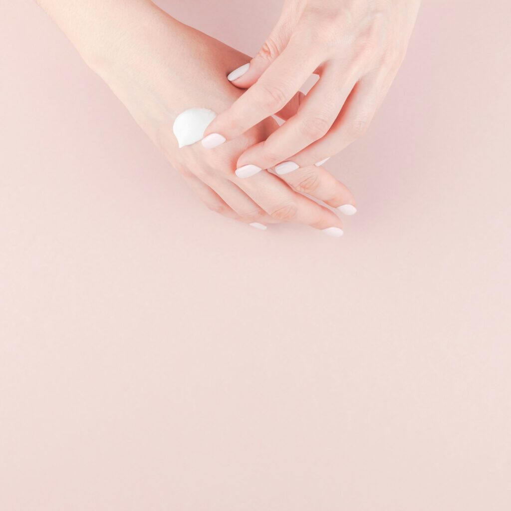 Woman moisturizing her hand with cosmetic cream